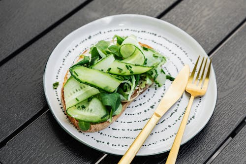 Sliced Cucumber on White Ceramic Plate with Cutlery