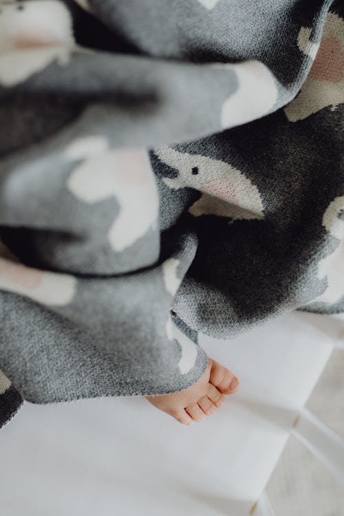 Free Foot of a Baby Sticking out from under a Blanket Stock Photo
