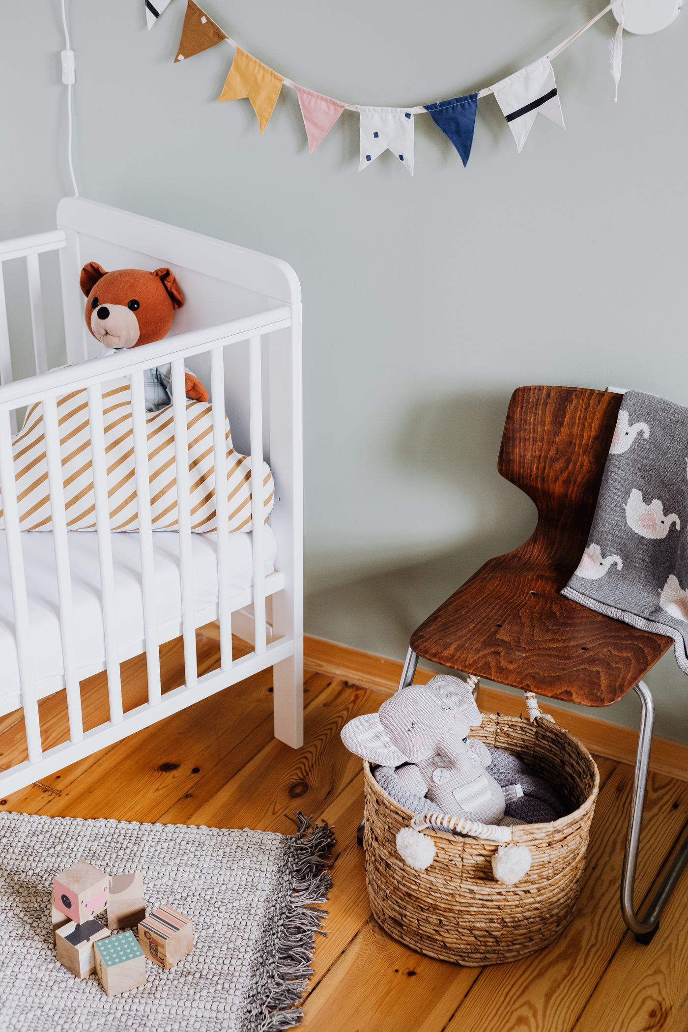 A bright, calm nursery with a white crib beside a wooden chair