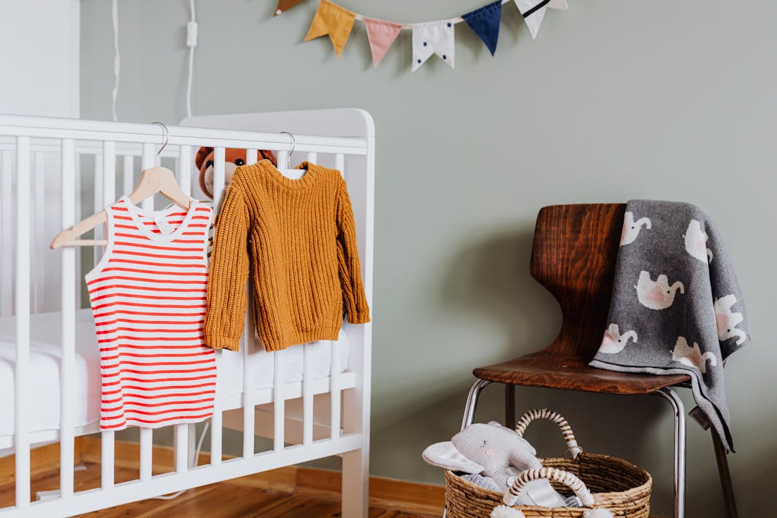 Free Photo of Baby Clothes Hanging on Crib Stock Photo