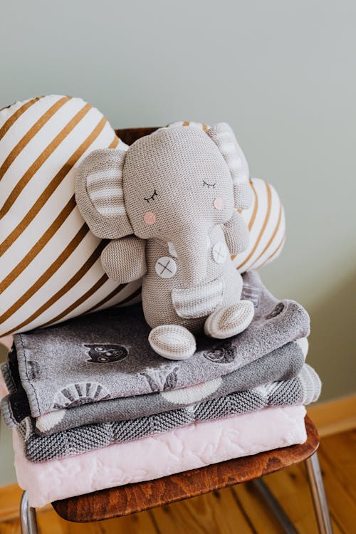 Close-up Photo of an Elephant Plush Toy on Top of Folded Blankets