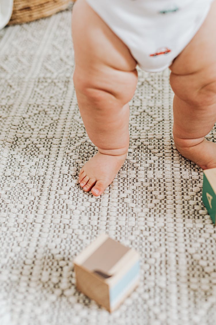 Baby Walking Among Scattered Toys