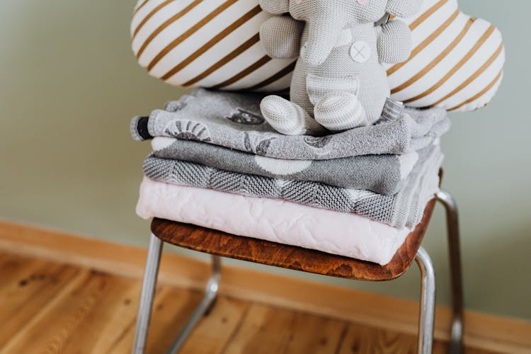 Blanket, Cushion And Toy Elephant On Chair