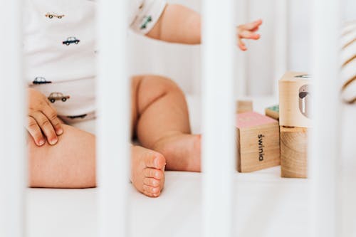 Free Baby Sitting in a Crib Stock Photo