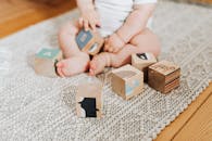 可爱的宝宝坐在地毯上，玩着五颜六色的木块