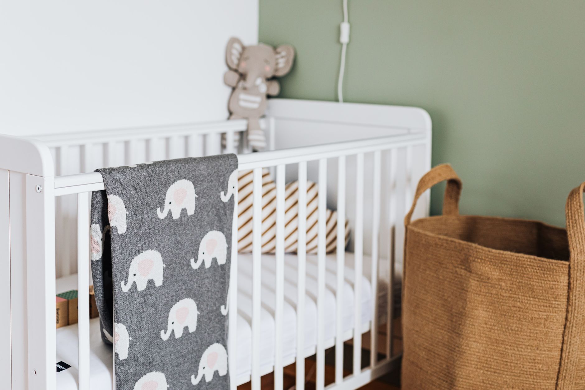 Stylish nursery featuring a cozy white crib with a cute elephant blanket.