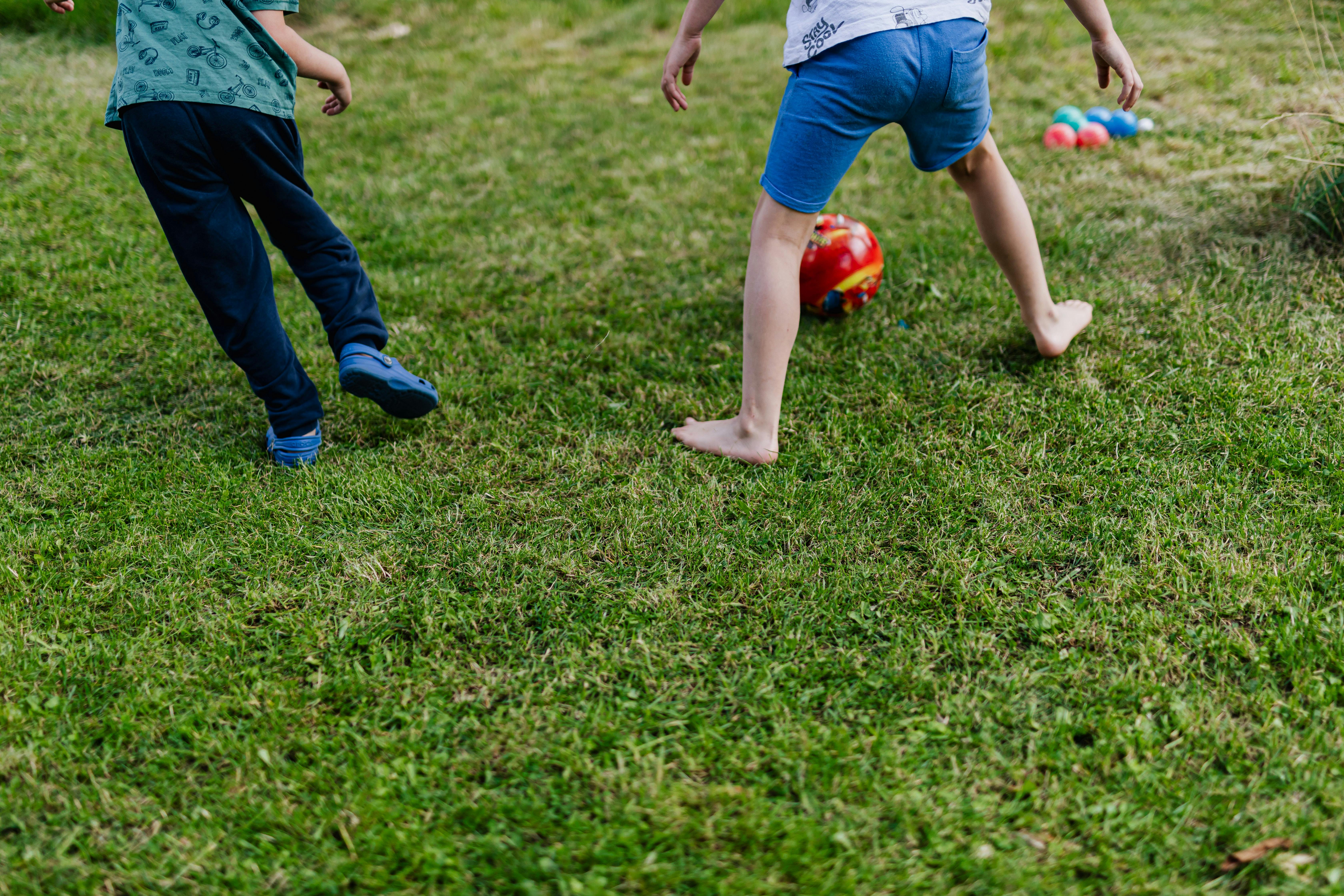 boys playing on green grass field