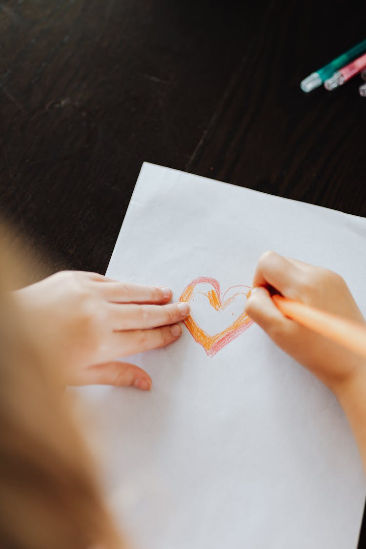 Kid Drawing A Heart On Paper