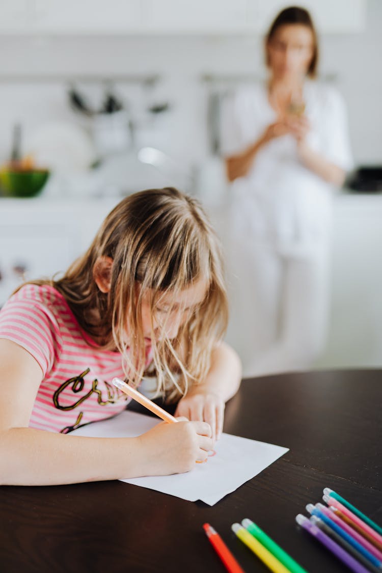 Girl In Pink And White Stripe Shirt Writing On White Paper