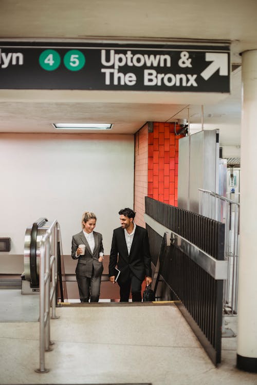 Man and Woman Wearing Blazers going Upstairs