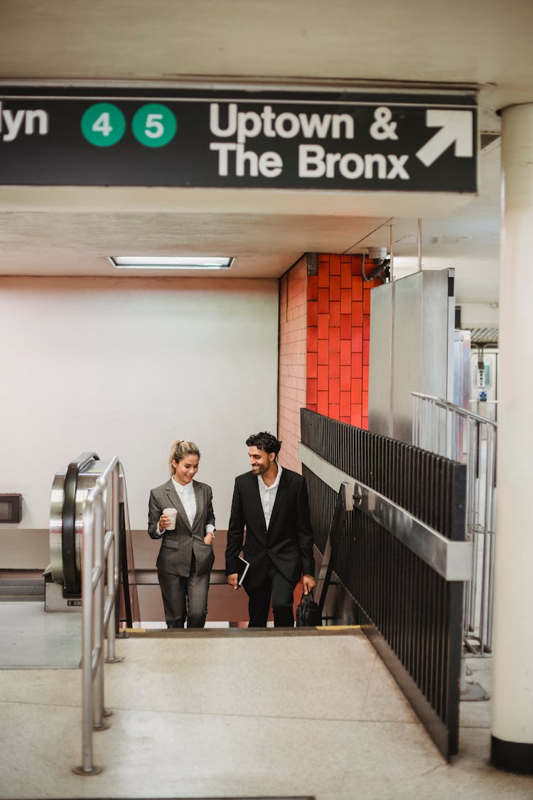 Man And Woman Wearing Blazers Going Upstairs