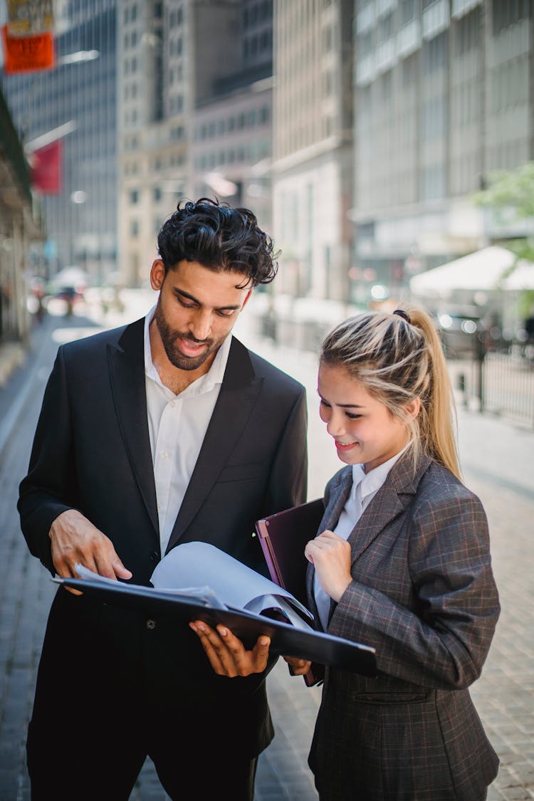 Man Discussing While Holding A Black Document Binder