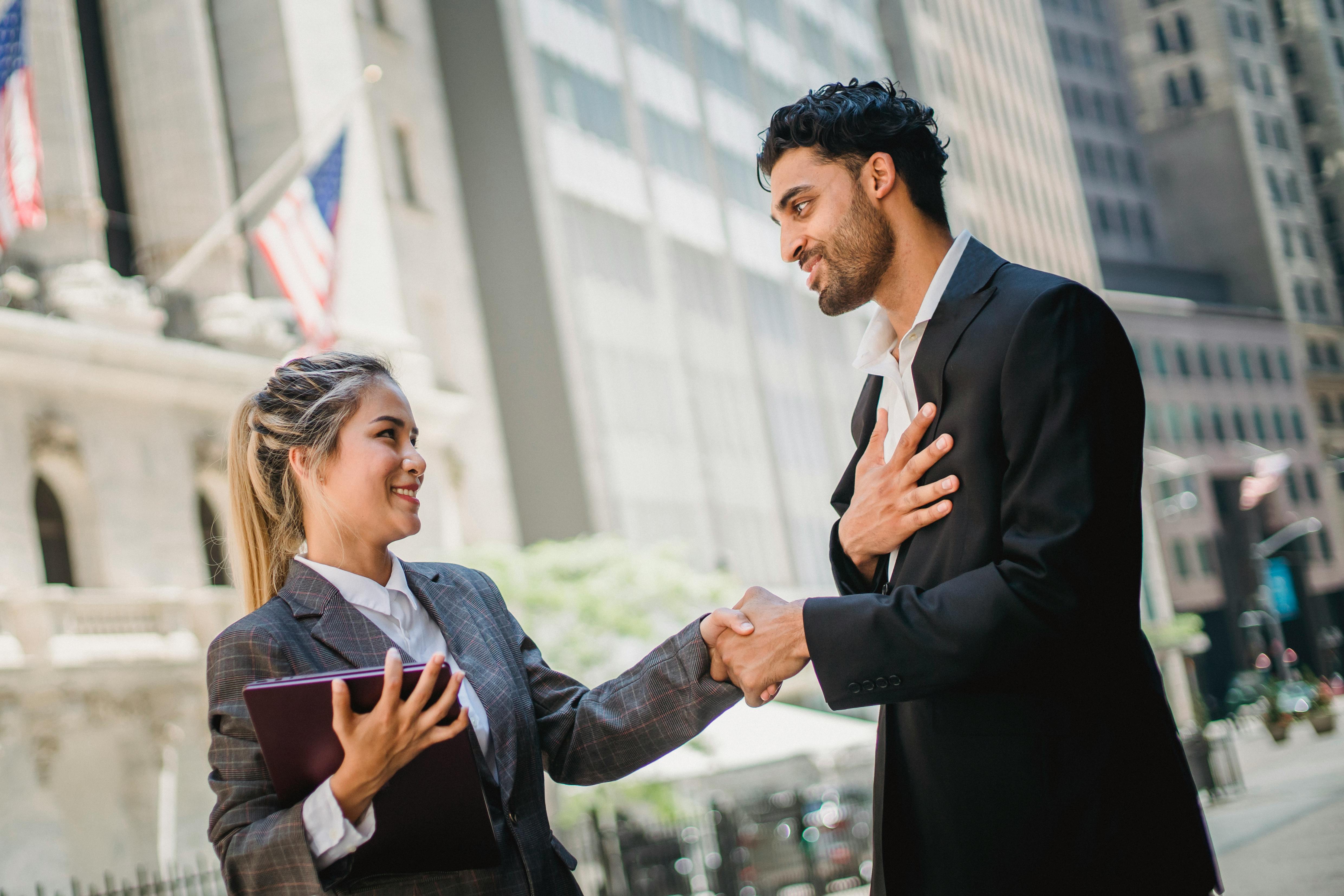Amerika'da iş dünyasında başarıyı yakalamak için kurulan güçlü iş ağlarını ve profesyonel iş birliğini temsil eden, modern bir ofis ortamında el sıkışan iş insanları.