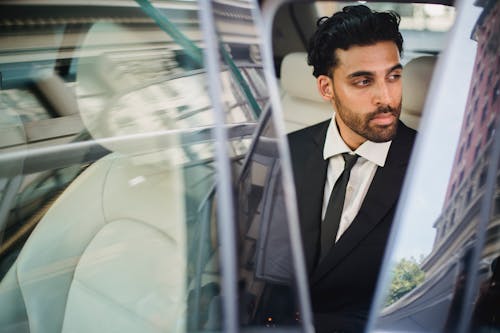 Man in Black Suit Sitting Inside a Car