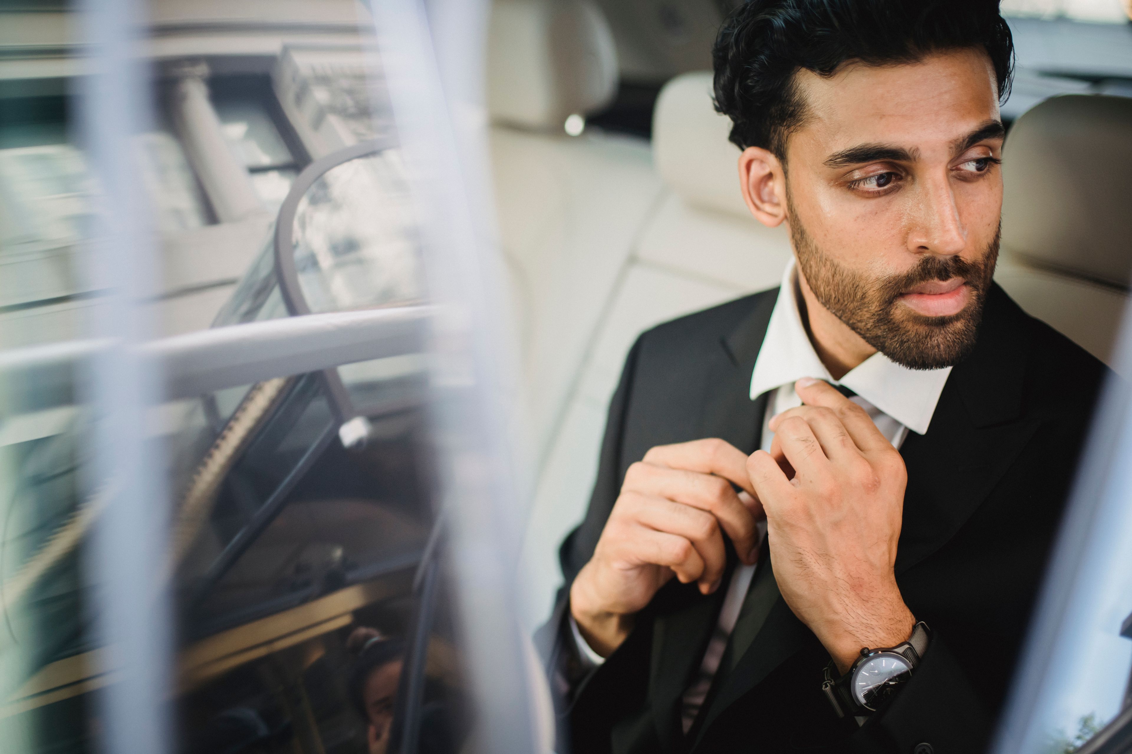 A chauffeur waiting beside a luxury car