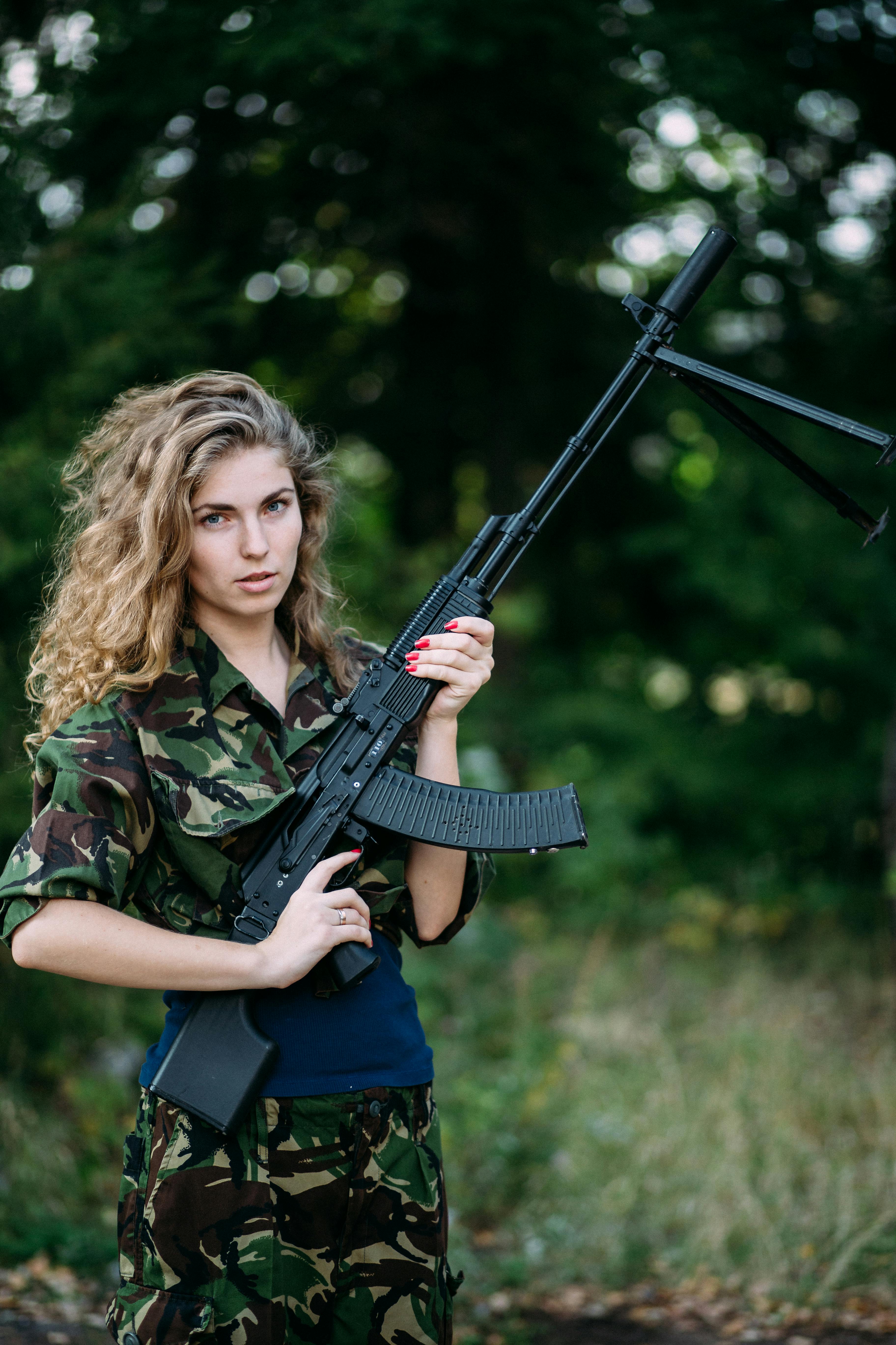 A Woman in a Military Clothing Holding a Rifle