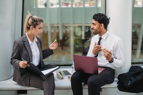 Businessman and Businesswoman Talking during Lunch Break