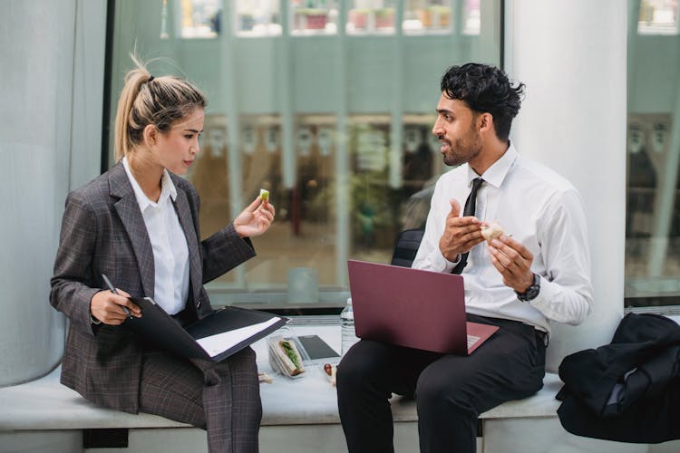 Businessman And Businesswoman Talking During Lunch Break