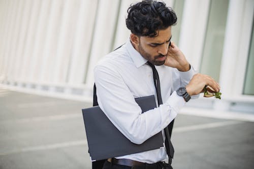 
A Bearded Man in a Corporate Attire Looking at His Watch