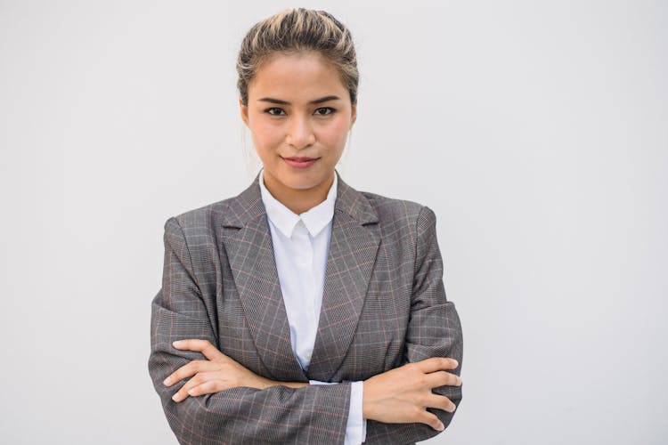 

A Woman In A Plaid Suit With Her Arms Crossed