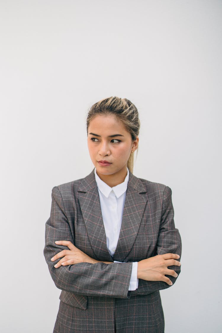 
A Woman In A Plaid Suit With Her Arms Crossed