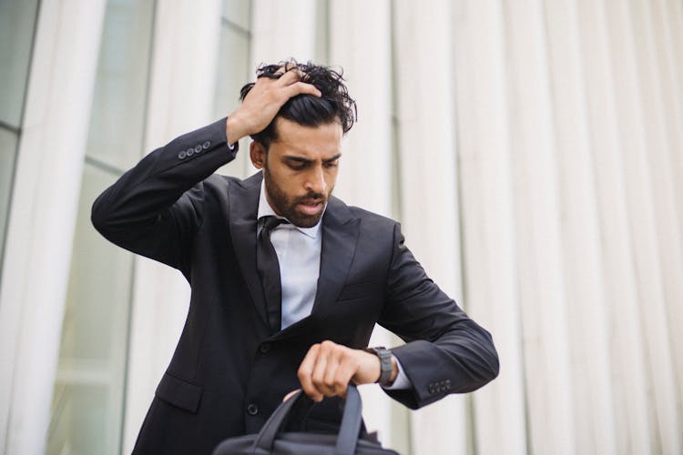 

A Bearded Man In A Suit Looking At His Watch