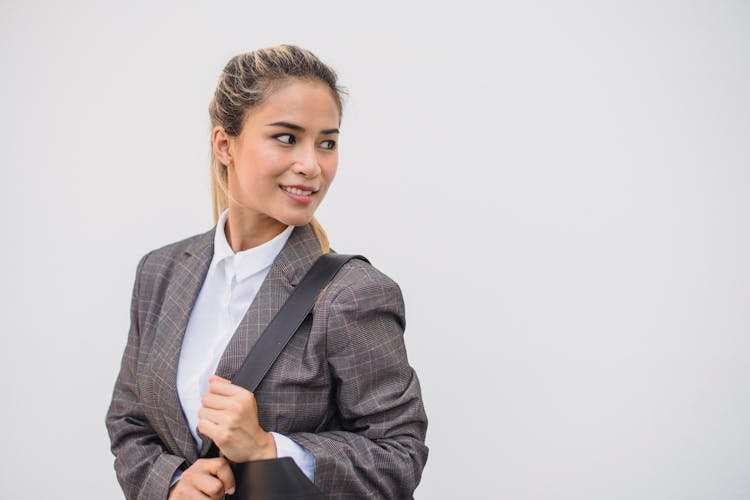 
A Woman In A Plaid Suit Carrying A Bag