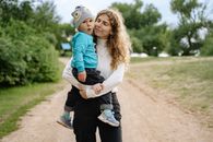 Woman in Blue Jacket Carrying Girl in Blue Jacket