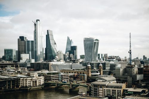 Free A stunning aerial shot of London's skyline featuring iconic skyscrapers under a cloudy sky. Stock Photo