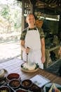 Woman in White and Brown Apron Holding White Ceramic Plate