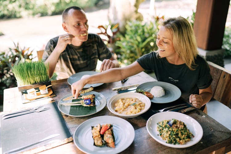 Man And Woman Eating Dinner On A Terrace