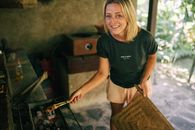 Woman in Black Crew Neck T-shirt and Brown Shorts Holding Brown Woven Basket
