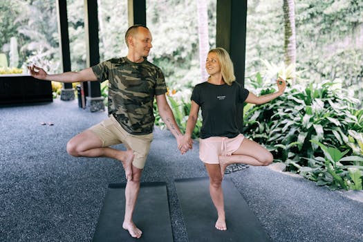A couple performing yoga poses on mats outdoors, enhancing wellness and connection.