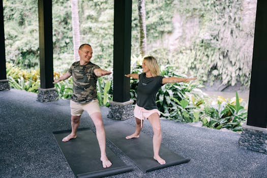 A happy couple doing yoga outdoors surrounded by lush greenery, embracing a healthy lifestyle.