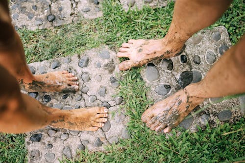 Close-up of Mans and Womans Dirty Feet Covered in Mud 