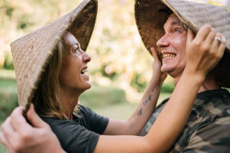 A Man And Woman Wearing Asian Conical Hat