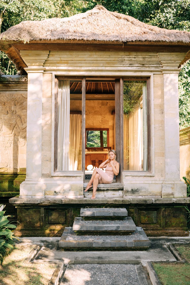 Woman Sitting On Steps In Front Of House