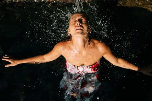 Woman enjoying a refreshing swim in sunlit outdoor pool, embodying summer vibes.