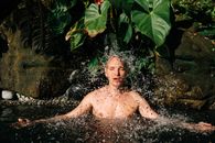 Topless Man in Water Near Green Leaves