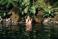 Woman in Water Near Green Leaves