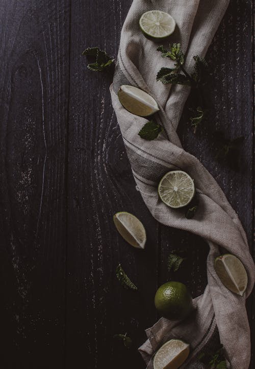 Free Brown Textile with Sliced Limes on Wooden Surface Stock Photo
