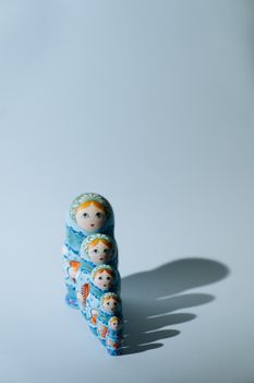 浅色背景上，一组蓝色的俄罗斯套娃投下了阴影