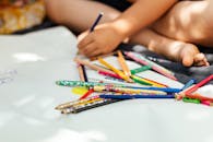 一个孩子用彩色铅笔在纸上创造性地画画，捕捉艺术时刻