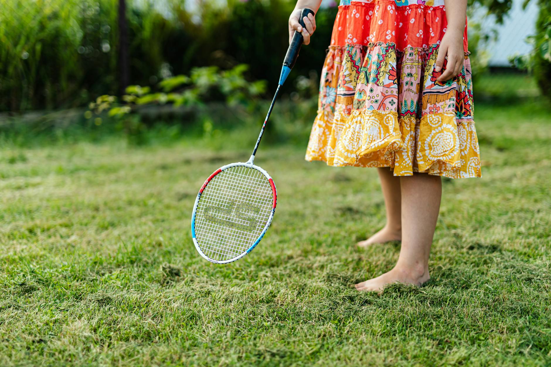 A Person in Floral Dress Holding a Badminton Racket
