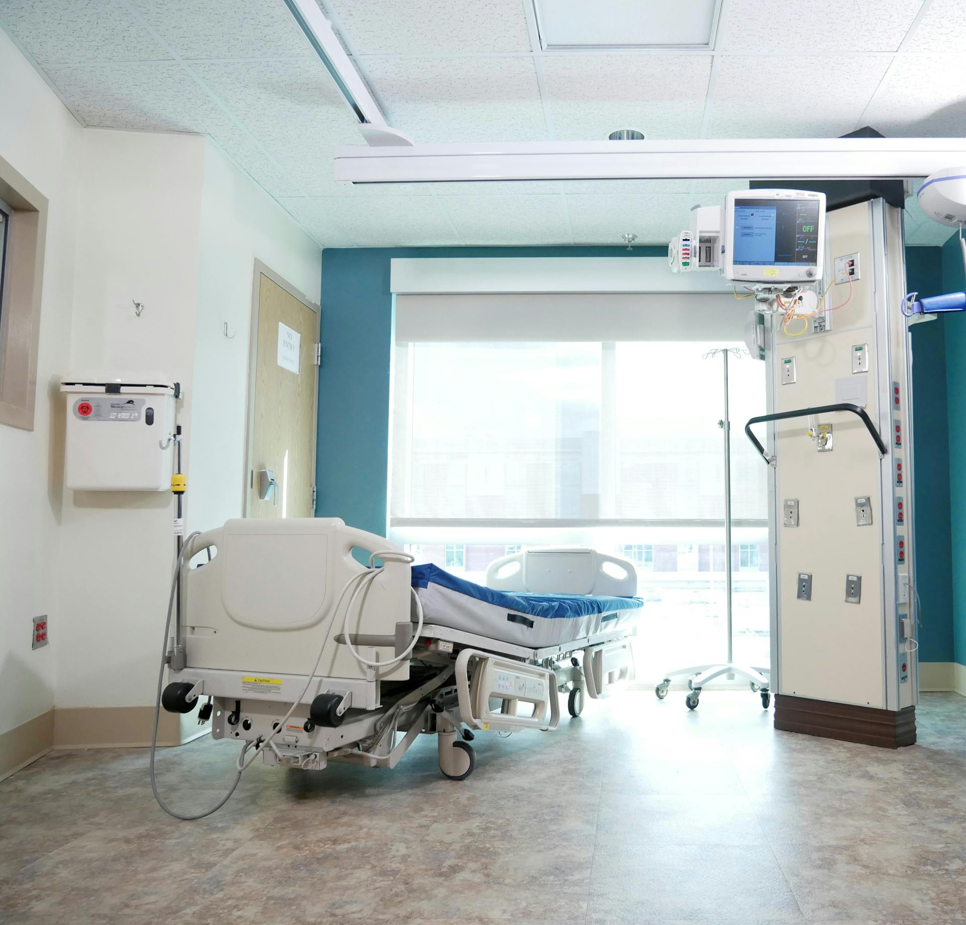 A well-equipped hospital room with a bed and advanced medical equipment.