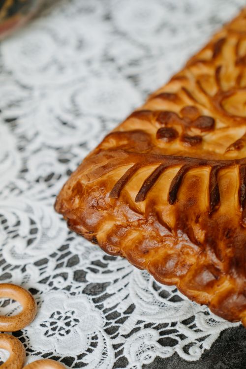 Free Close-up of traditional Russian baked goods on an ornate lace tablecloth. Stock Photo