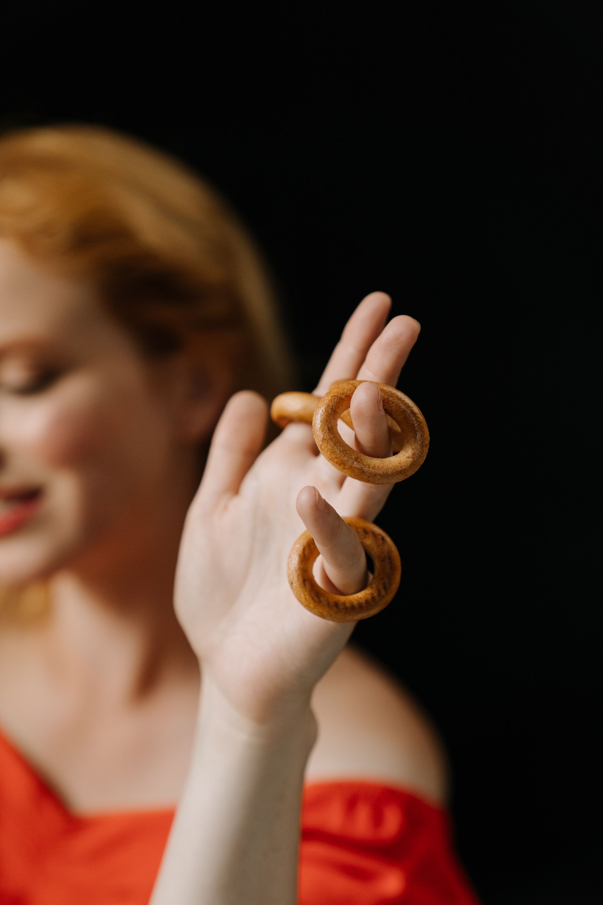 A creative image focusing on Russian sushki on a hand, with a blurred artistically lit background.