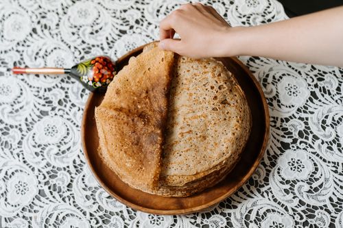 Free A stack of delicious traditional Russian blini on a lace tablecloth, perfect for a cultural meal. Stock Photo