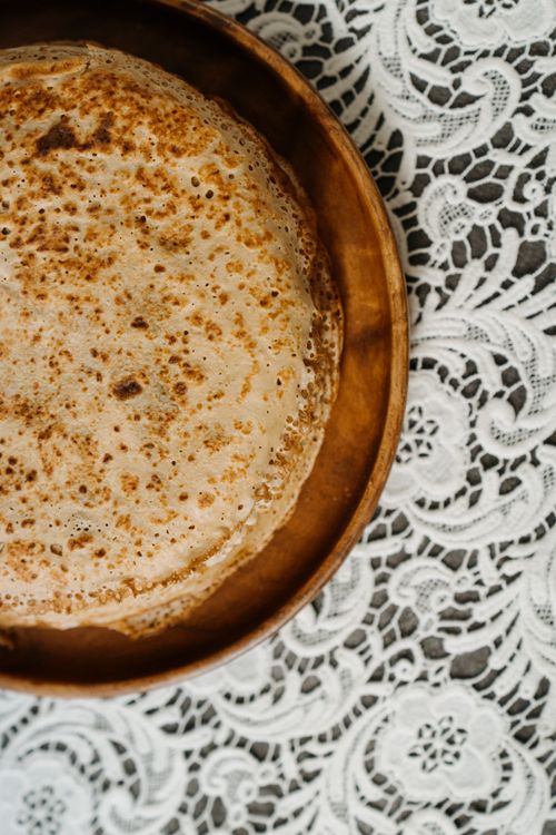 Free Close-up of blini on a lace tablecloth, highlighting Russian cuisine tradition. Stock Photo