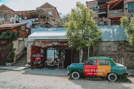 Exterior of aged stone buildings with vintage car parked near restaurant in sunny day